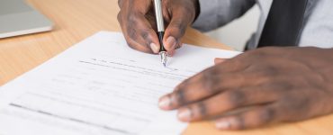 person holding gray twist pen and white printer paper on 955389