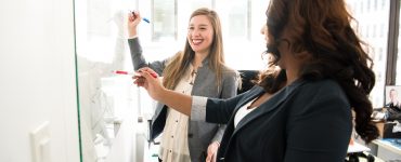 two women in front of dry erase board 1181533